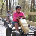 Kid enjoying a pedal cart ride, one of the fun 5 pack activities.