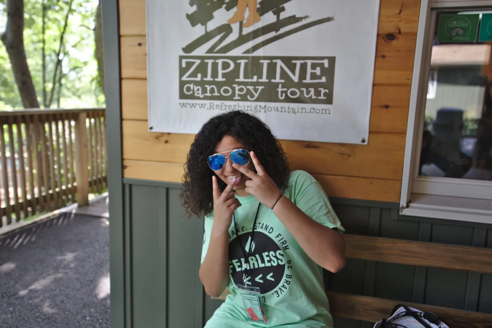 A girl posing for a picture in front of Refreshing Mountain's office for Zipline Canopy Tours