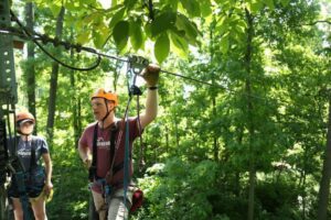 Nick Cage, a member of the Refreshing Mountain admin staff , instructing people on the zipline course.